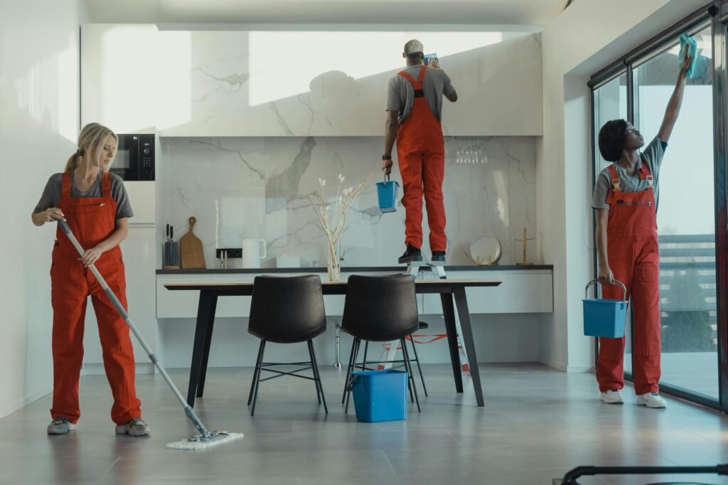 3 professional cleaners working on a kitchen